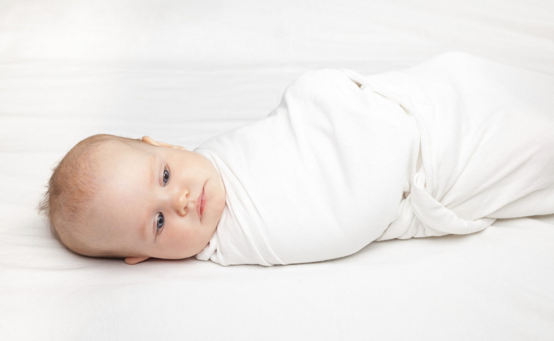 sleeping baby swaddled in blanket