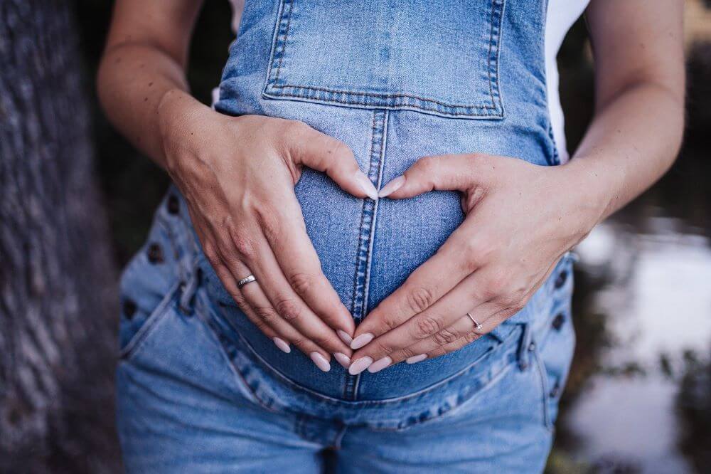 pregnant lady heart hands on stomach